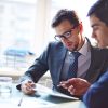 Serious businessman listening to his colleague explanations at meeting