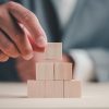 Hand,Stack,Woods,Block,Step,On,Table.,Business,Development,Concept.copy